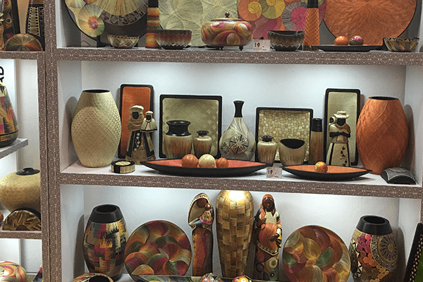 A shelf with many different types of vases and plates.
