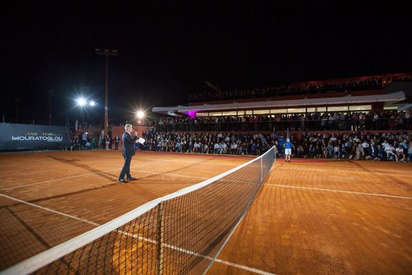 A man standing on top of a tennis court holding a racquet.