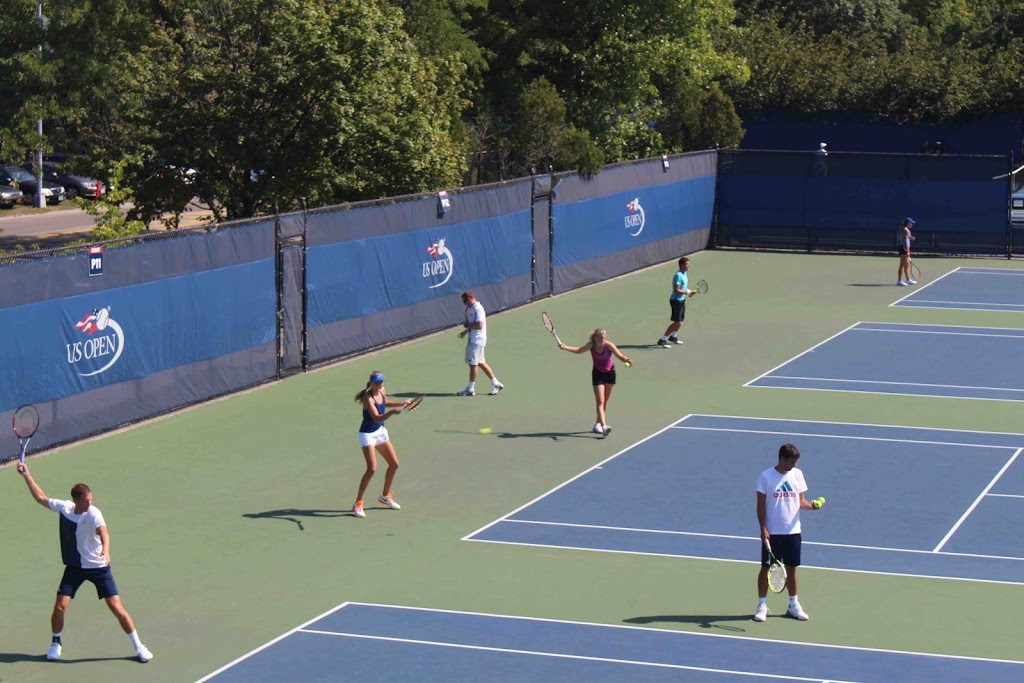 A group of people playing tennis on a court.