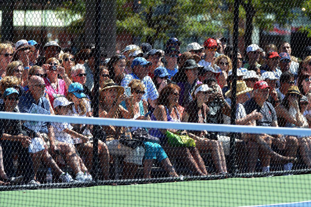 A crowd of people watching a tennis match.