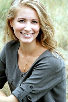 A woman with long blonde hair smiling for the camera.