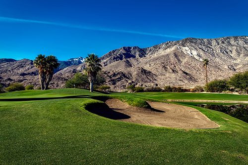 A golf course with mountains in the background.