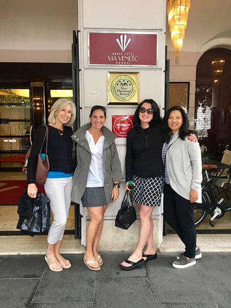 Four women are posing for a picture outside of the majestic hotel.